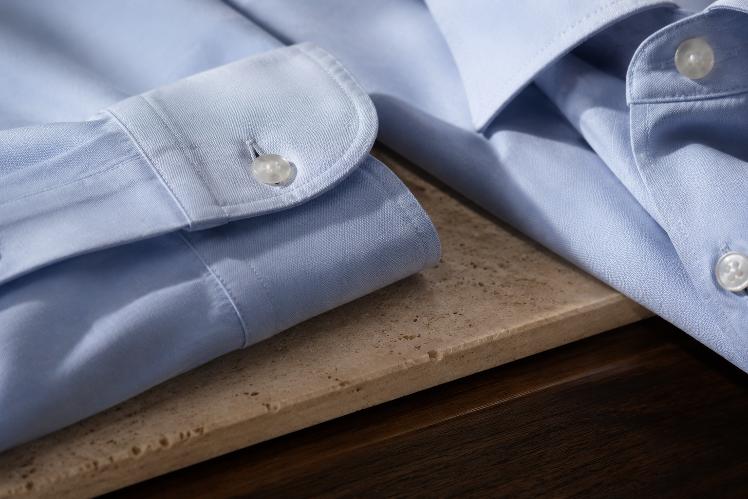 Close detail of pale blue cotton, cuff and mother-of-pearl buttons